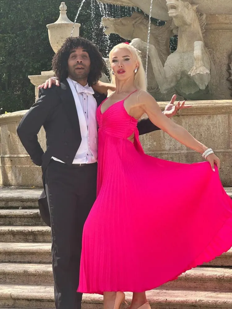 Ballroom dance couple posing outdoors near a fountain
