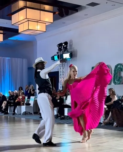 Ballroom dance couple performing in formal attire