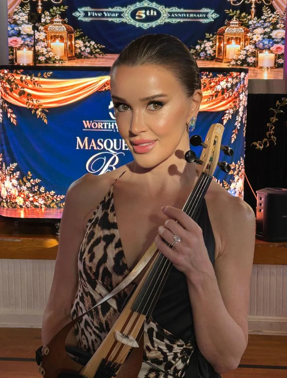 Anna Cordin with her violin in a black and leopard-print gown